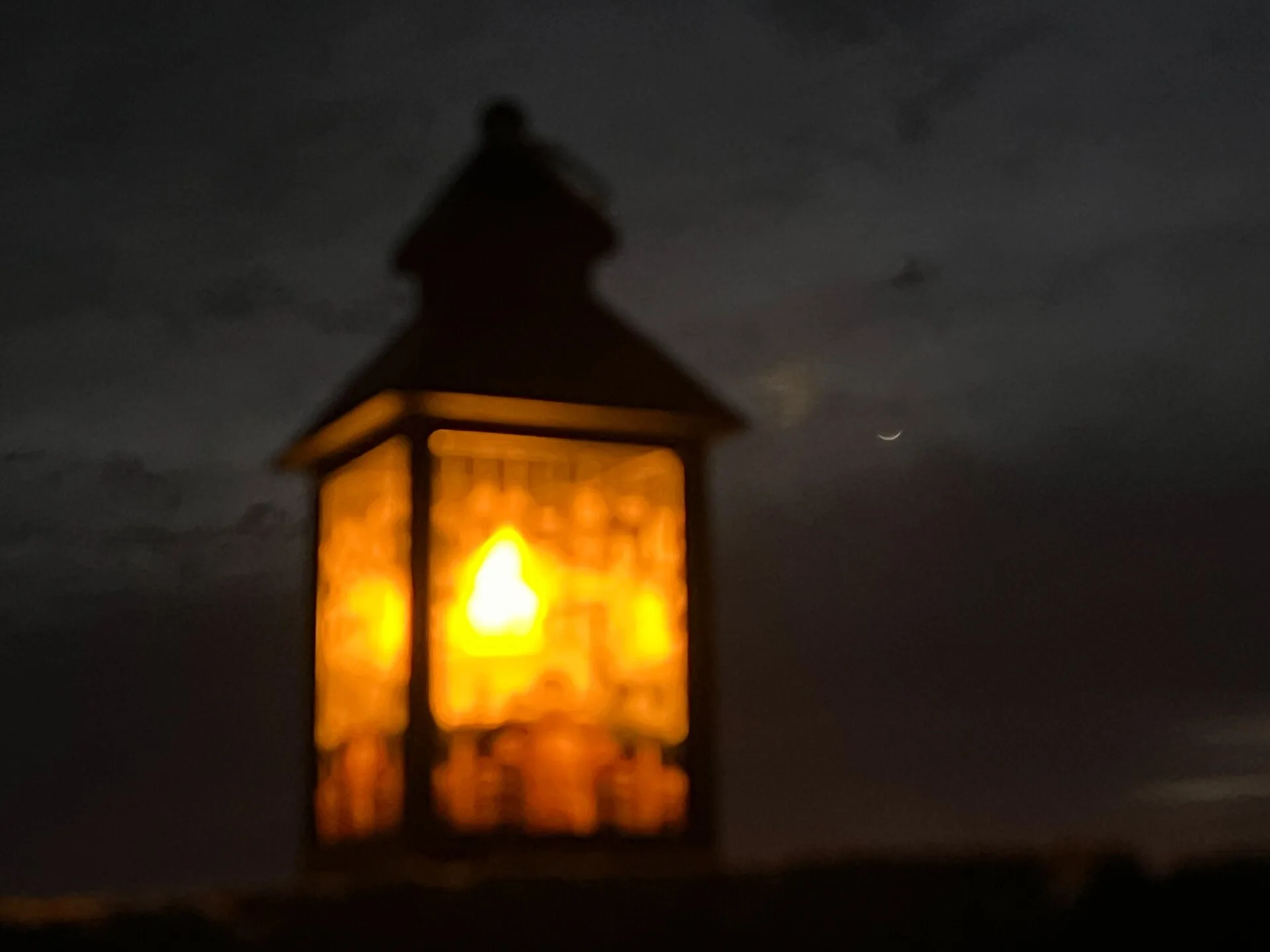 Lanterne allumée et croissant de lune dans le ciel du soir
