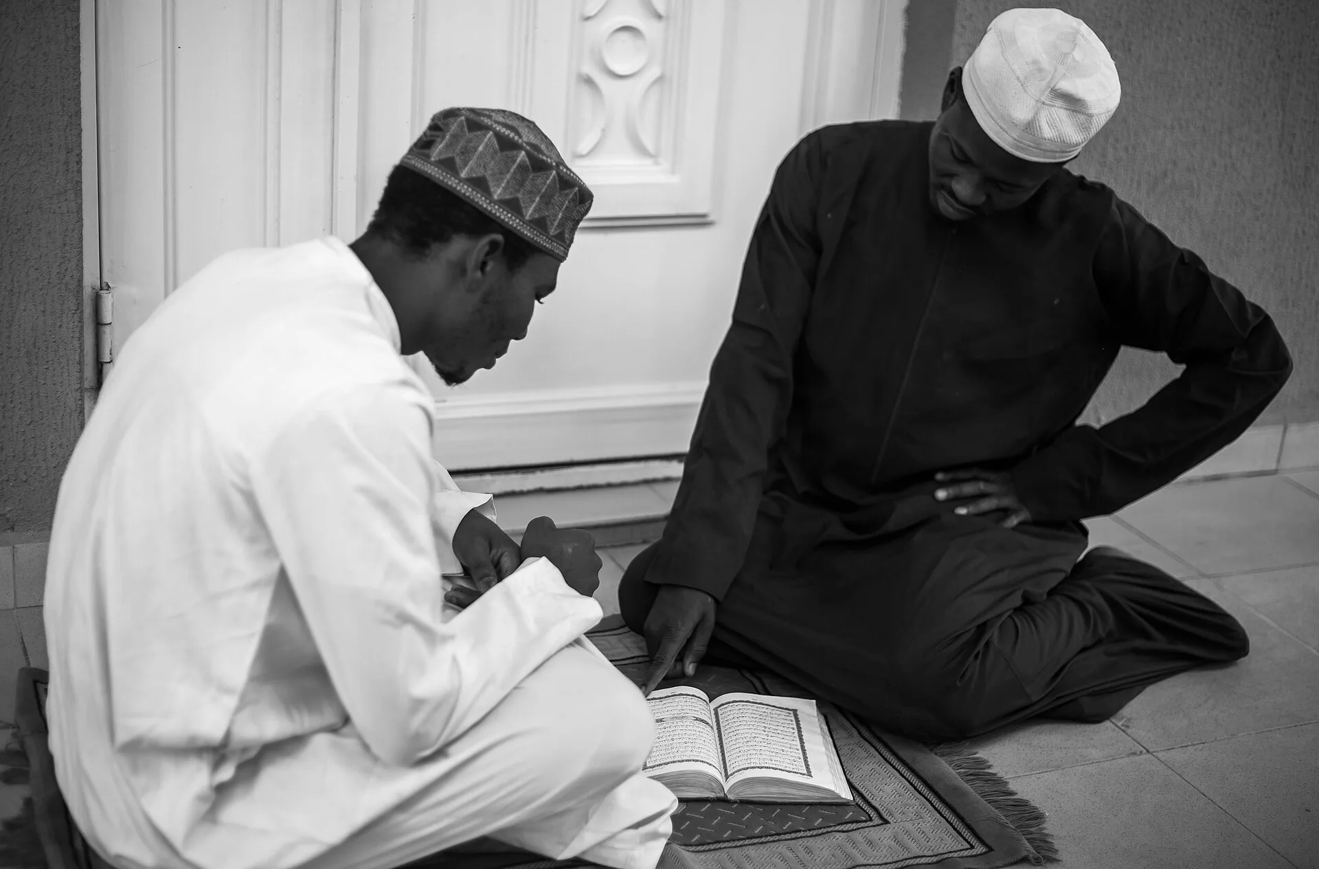 Enseignant transmettant la lecture du Coran, un chapelet à la main